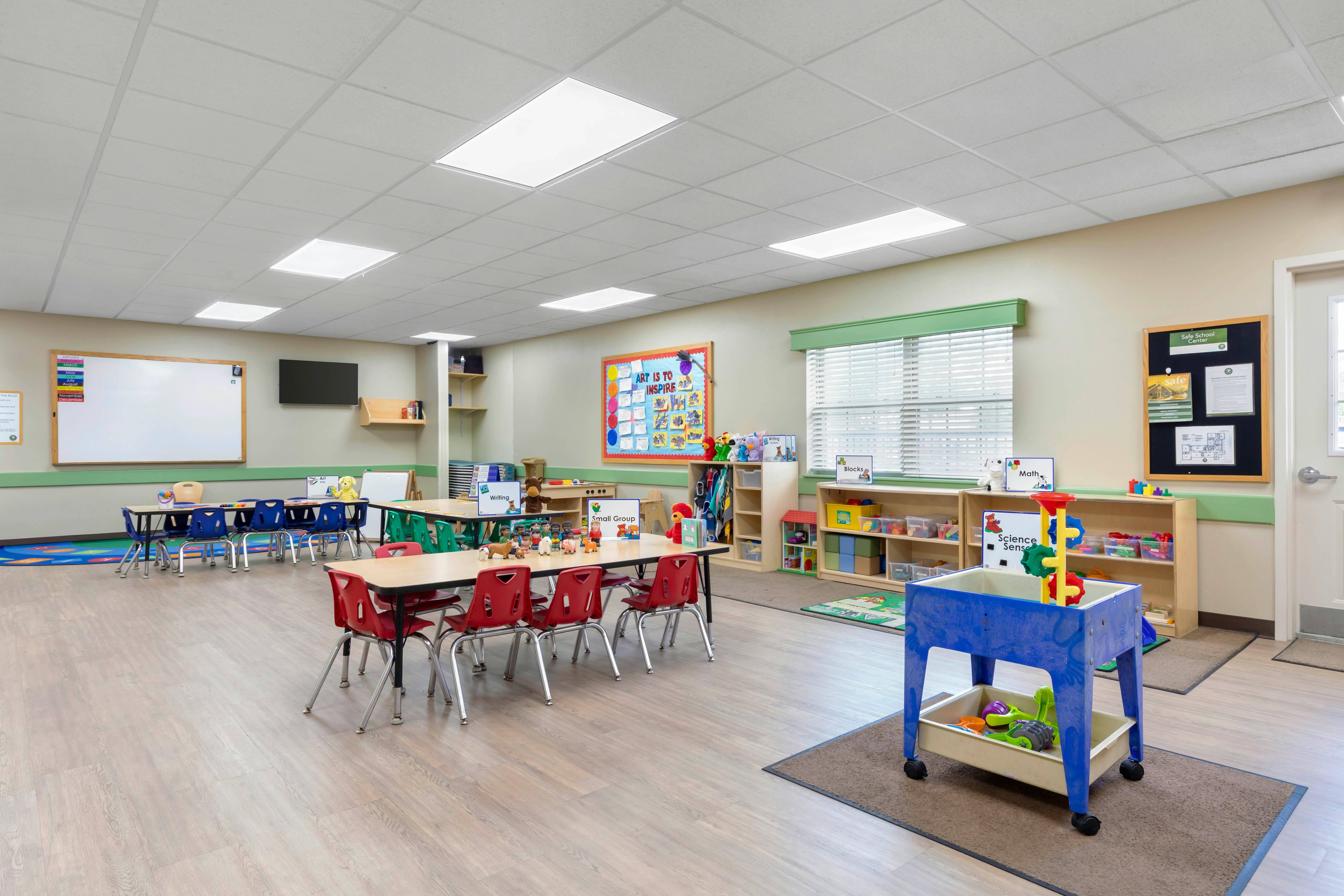 Classroom with tables, chairs, and learning stations
