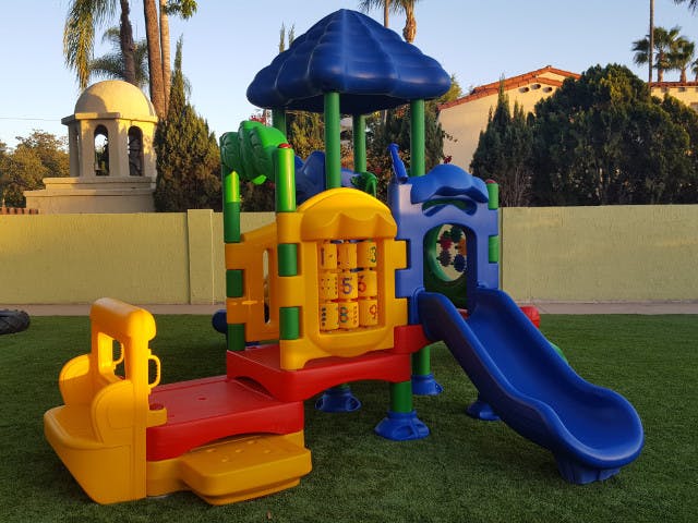 Colorful playground structure with a blue slide on green grass