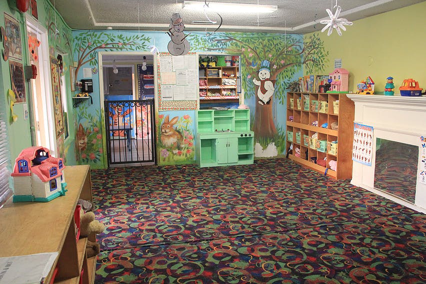 Playroom with colorful carpet, murals, and shelves