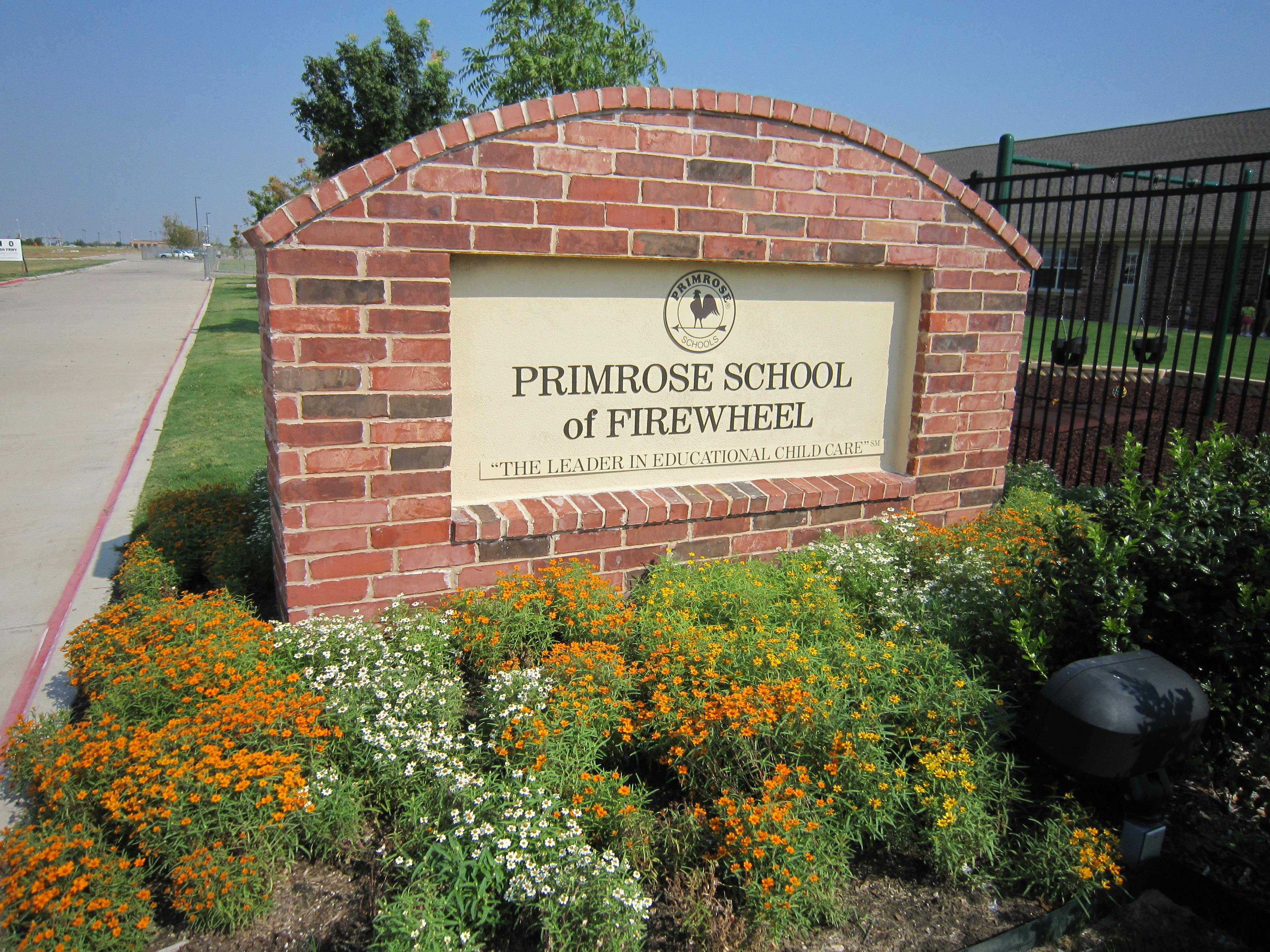 Brick sign for Primrose School of Firewheel surrounded by flowers