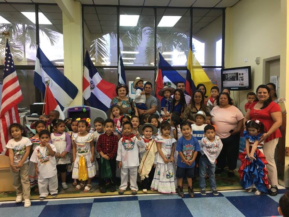 Group of adults and children standing in front of flags