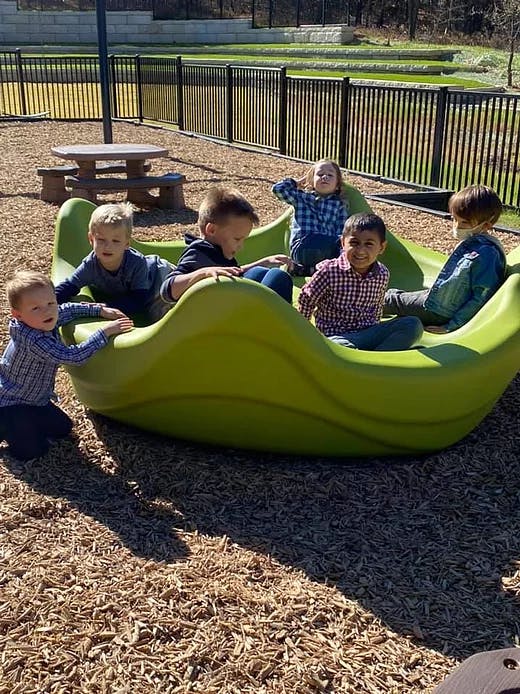 Children playing on a green playground structure