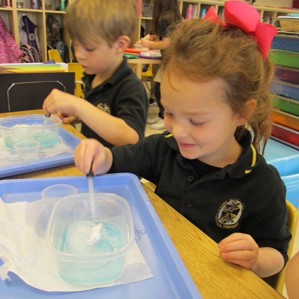 Child using a dropper with a container of liquid and ice