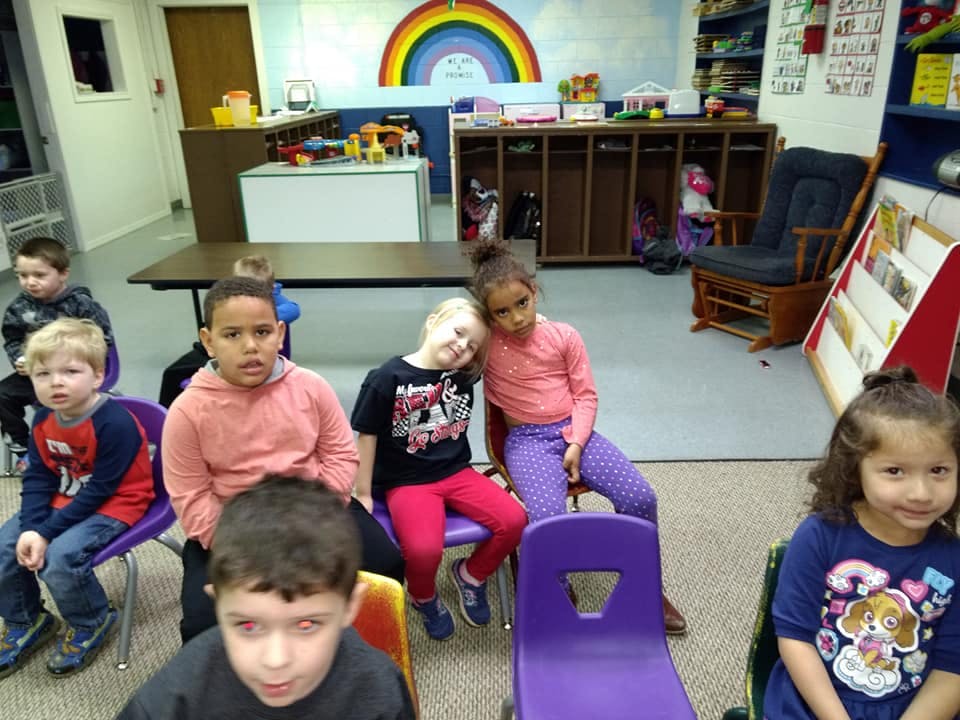 Children sitting on chairs in a classroom