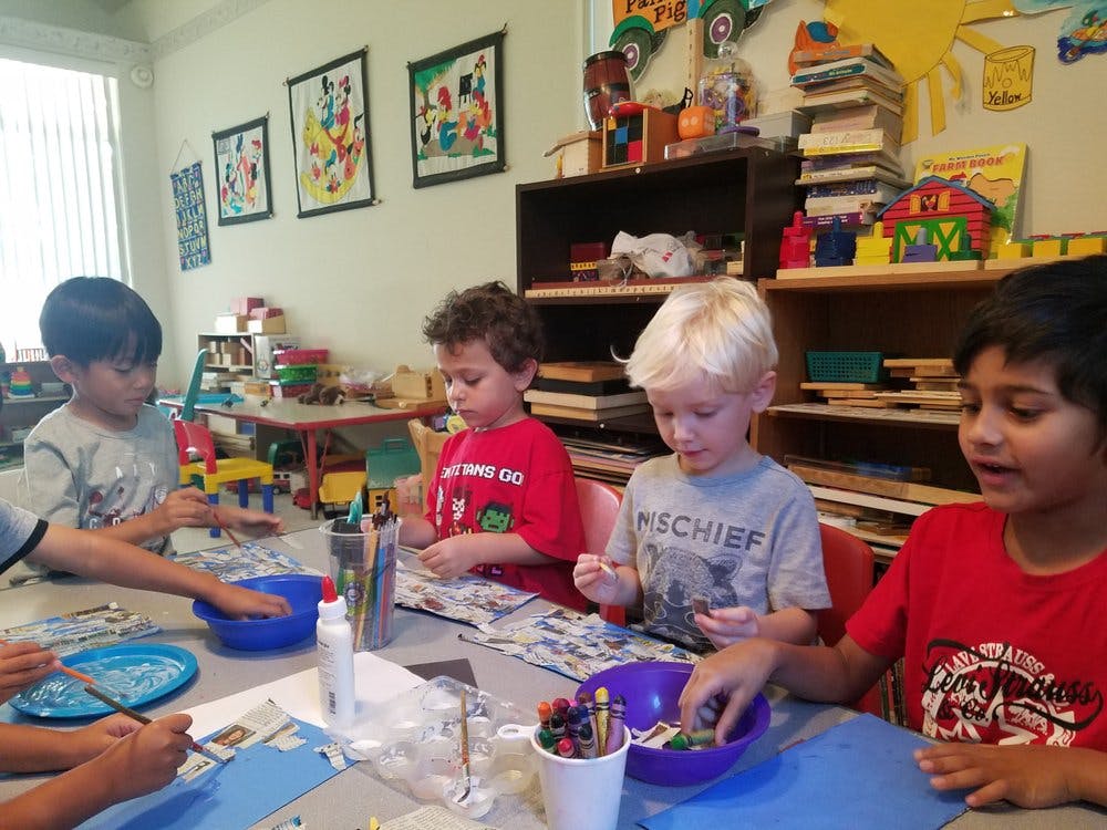 Children sitting at a table doing an art activity