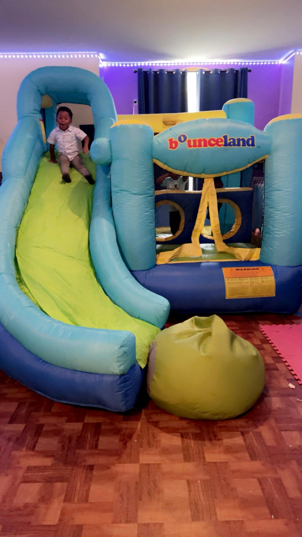 Child sliding down an indoor inflatable bouncer