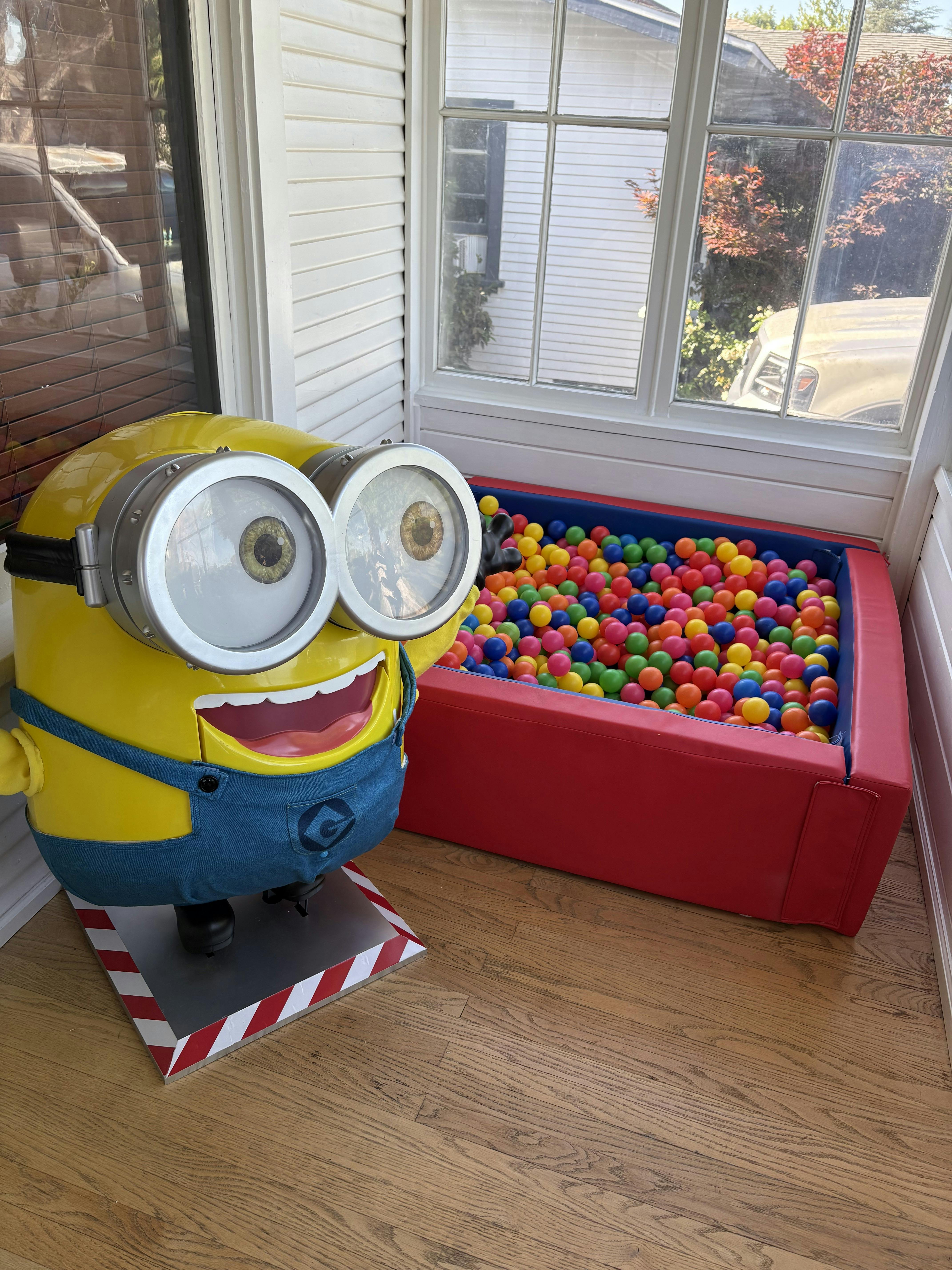 Minion character figurine next to a small ball pit on a porch