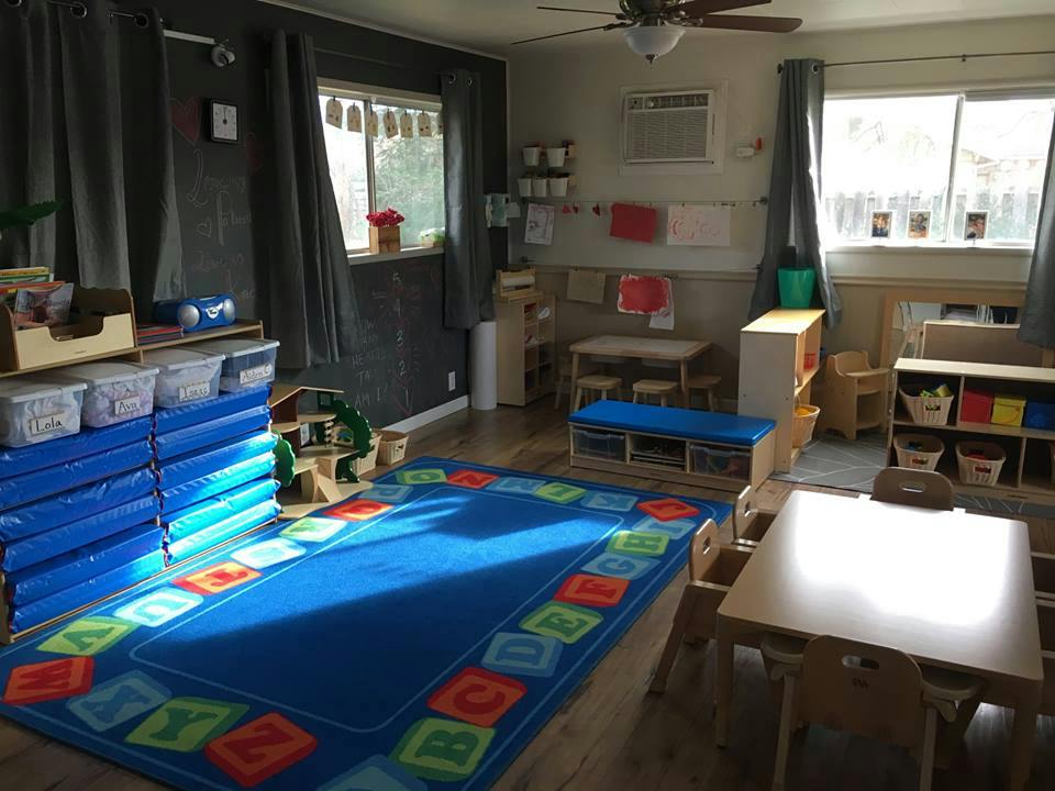 Empty classroom with a blue rug and small tables
