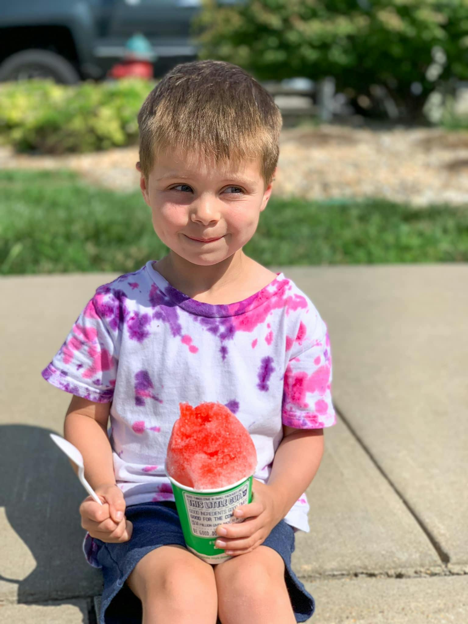 Child holding a cup of shaved ice and a spoon