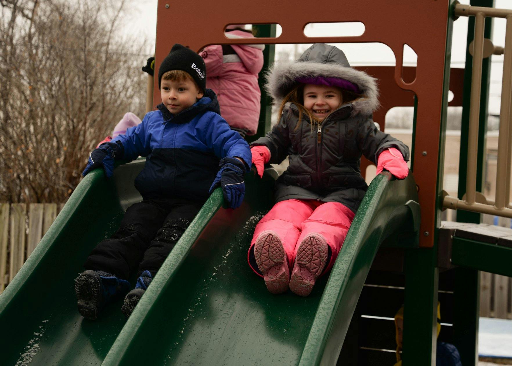 Two children on playground slides
