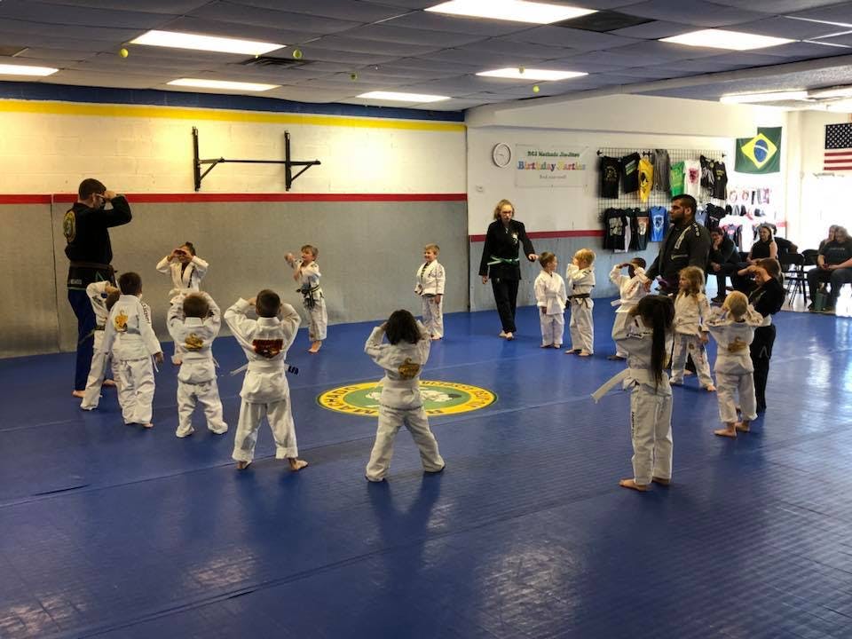 People and children in martial arts uniforms in a studio
