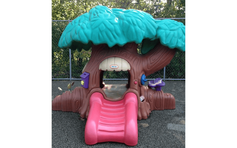A treehouse-shaped play structure with a red slide and the Little Tikes logo