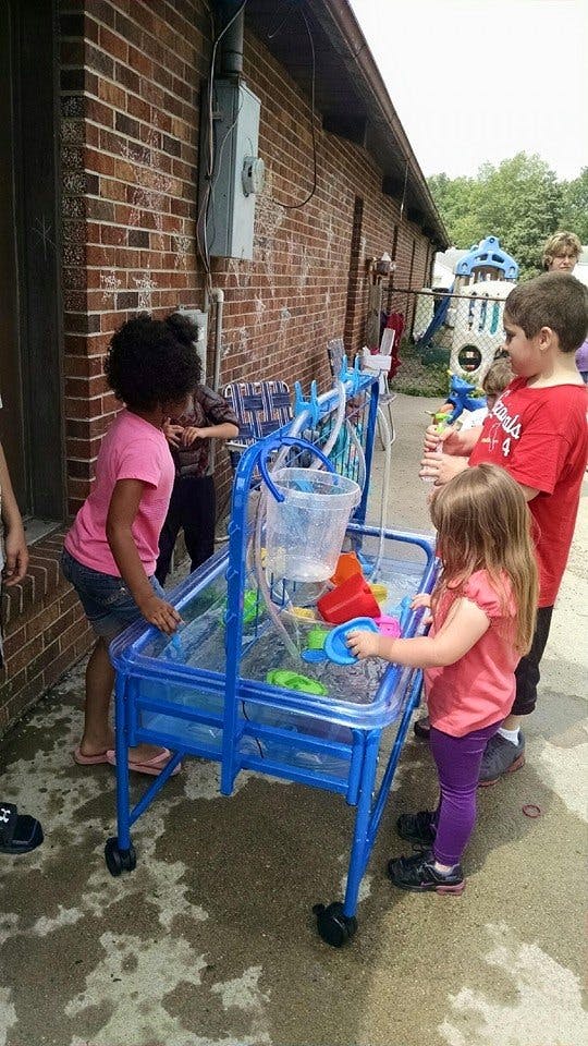 Children playing with a water table outdoors