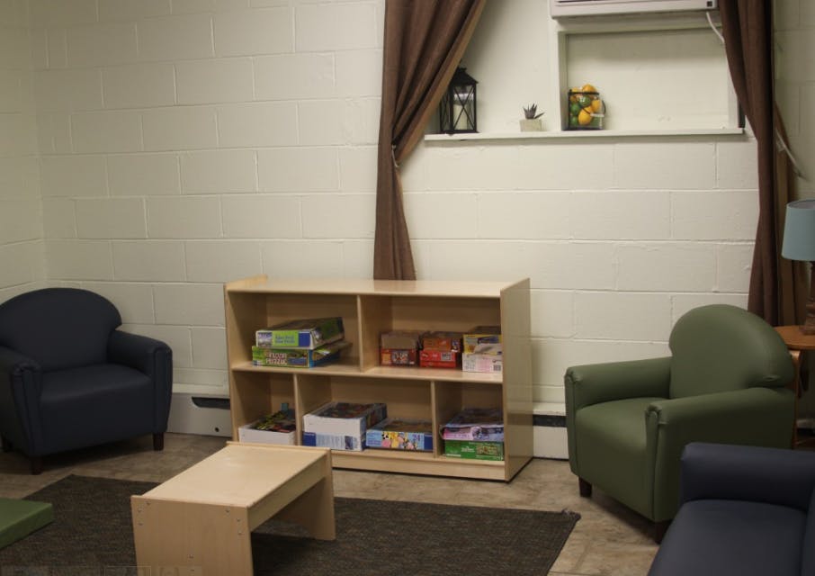Room with chairs, a bookshelf, and a coffee table