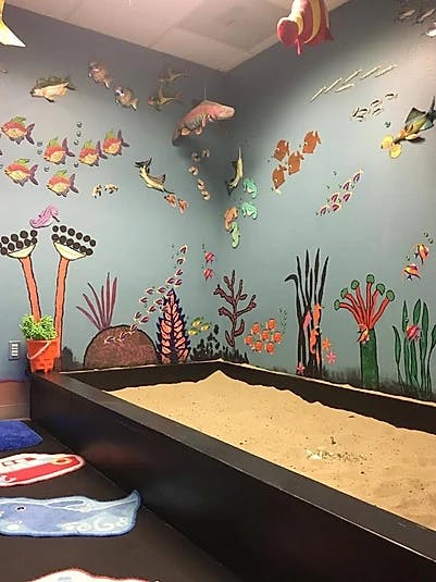 Indoor sandbox with ocean-themed wall murals