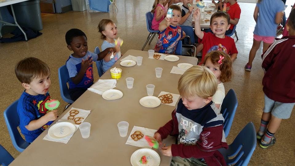 Children sitting at a table with snacks