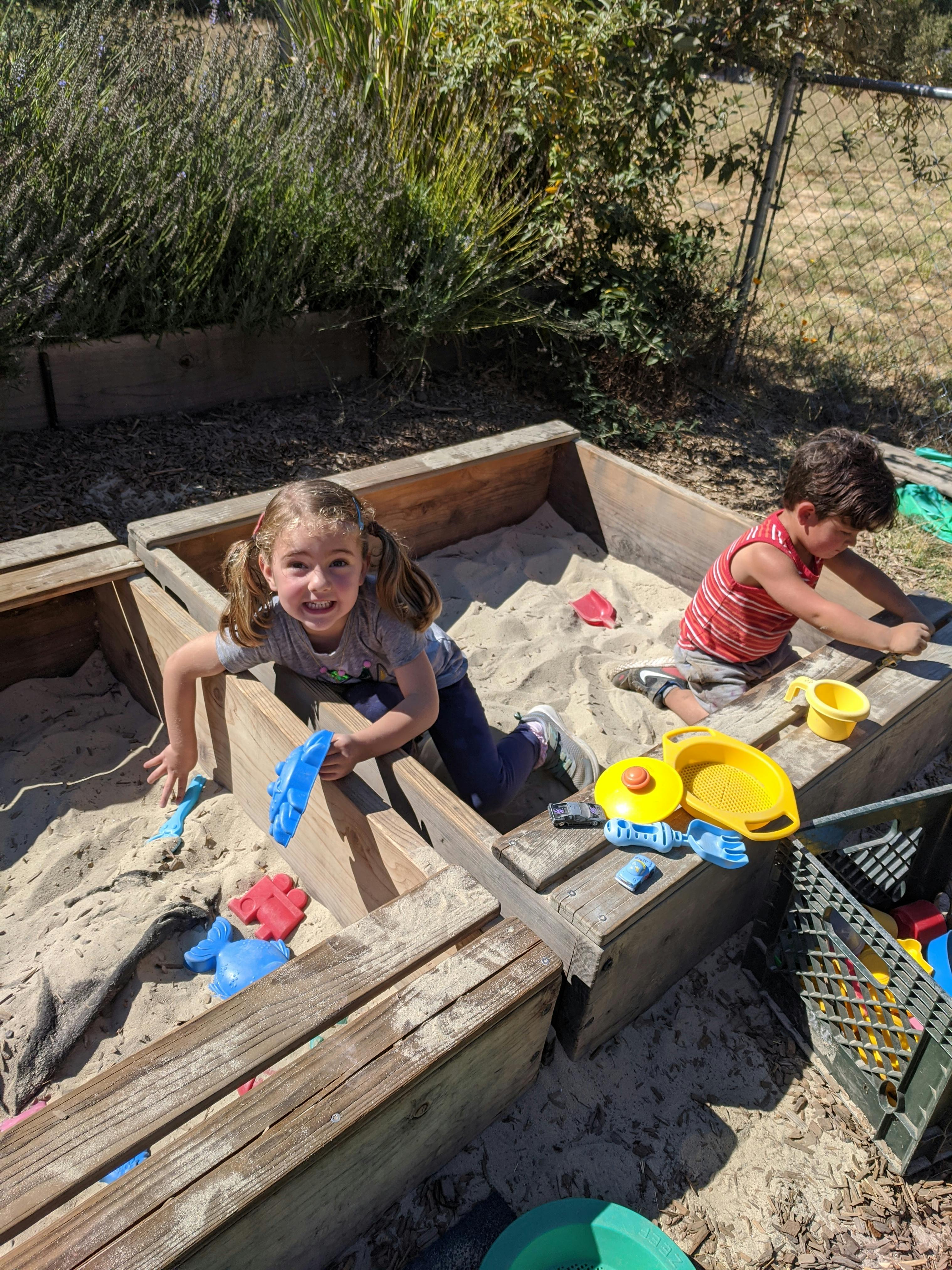 Two children playing in a sandbox