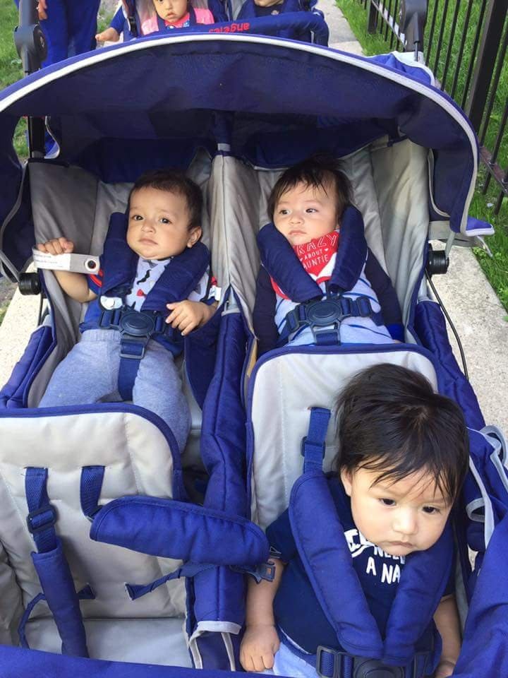 Three children in a multi-seat stroller