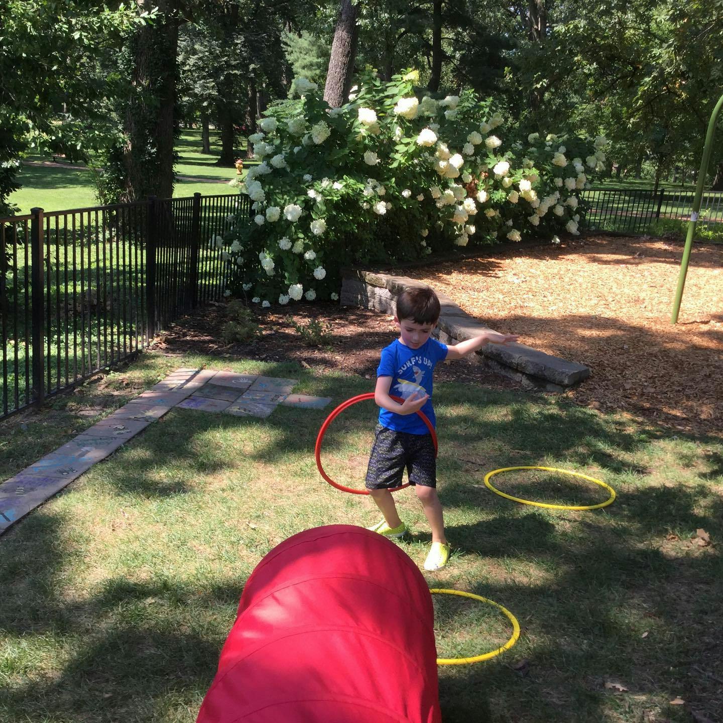 Child playing with hula hoops on grass
