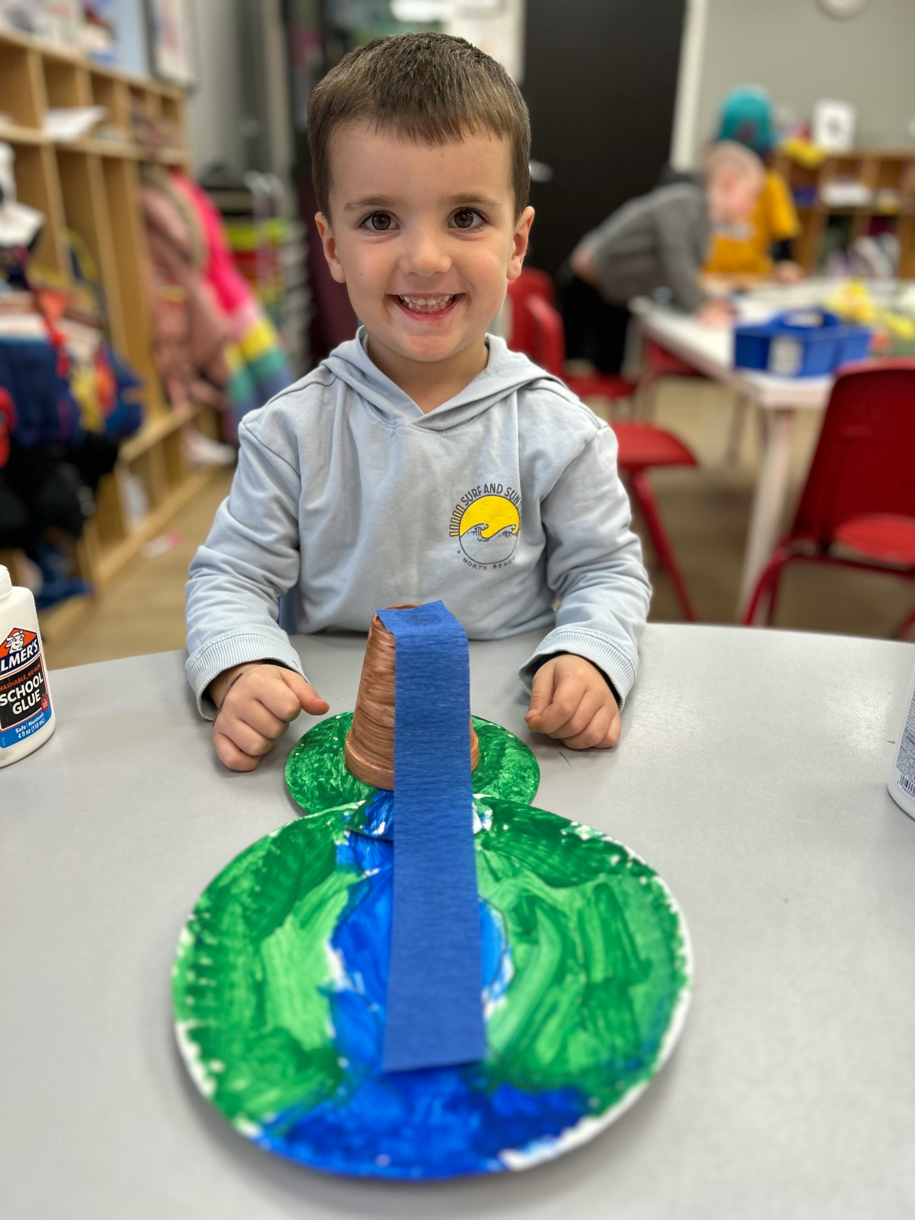 Child sitting at a table with a craft project