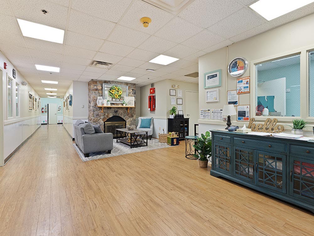 Lobby area with a fireplace and seating next to a long hallway