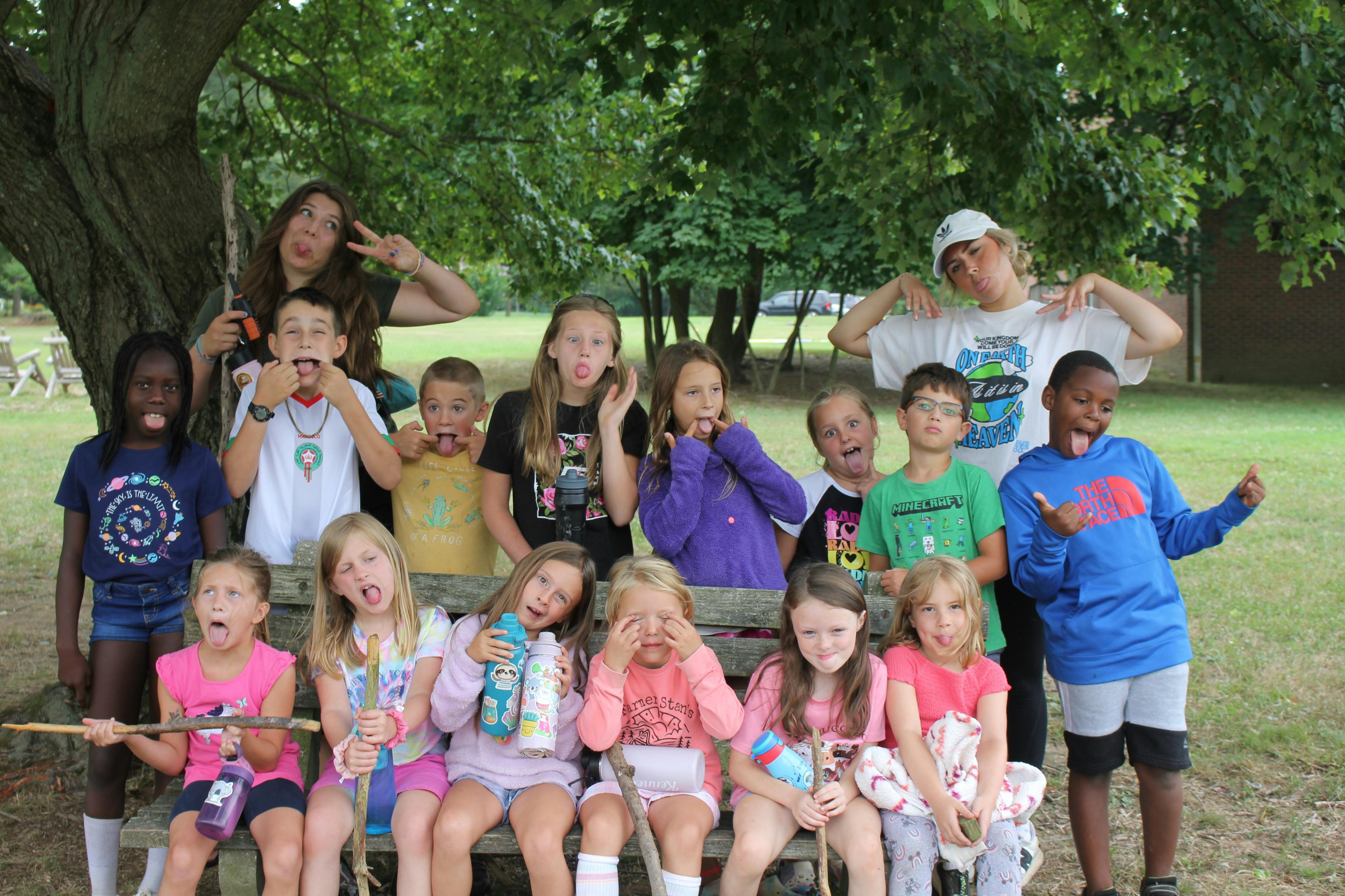 Group of children and teens making silly faces outdoors