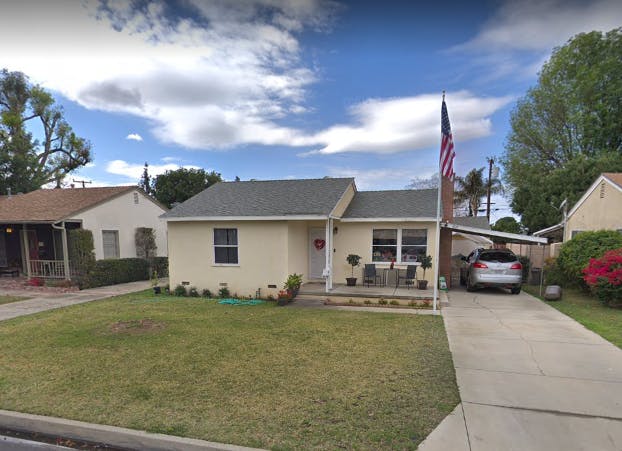 Single-story house with a lawn and a car in the driveway