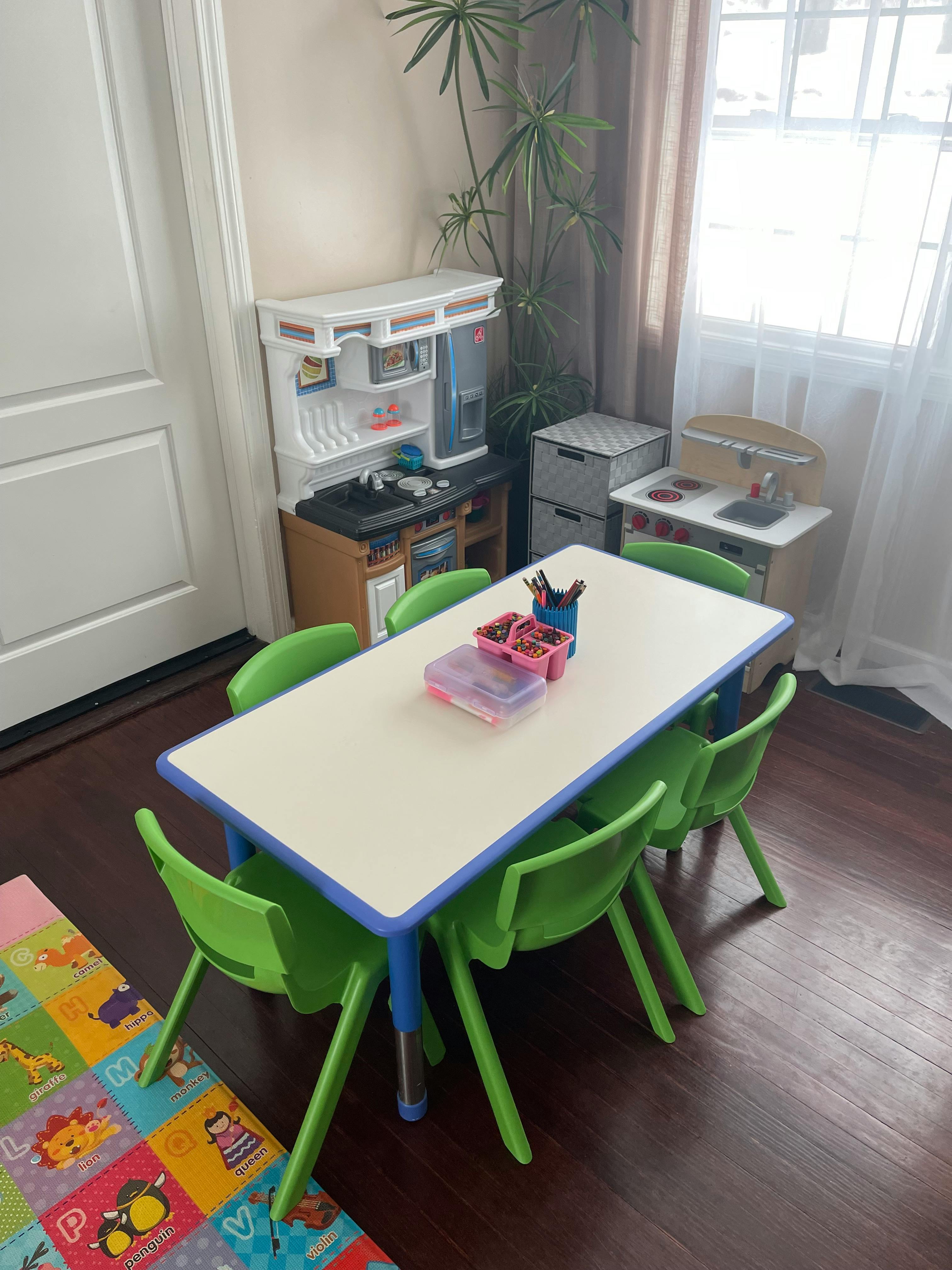 Children's play area with a table, chairs, and toy kitchen