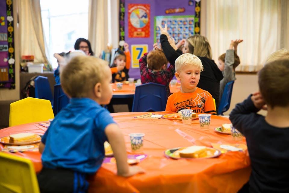 Children sitting at tables in a classroom