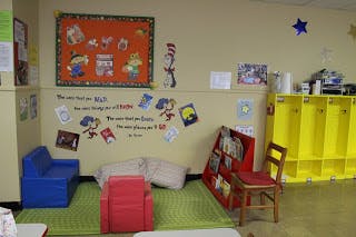 classroom with small blue couch, red chair, and yellow lockers