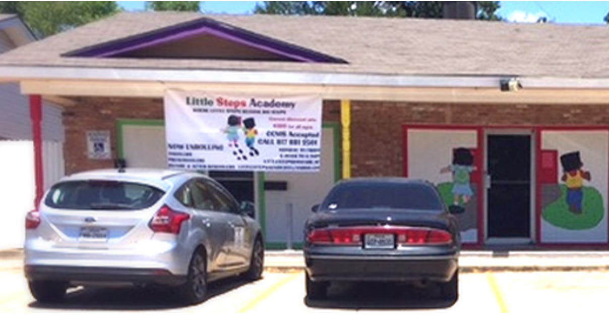 Building with a banner that reads "Little Steps Academy" and two cars parked in front
