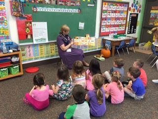 Adult reading to children in a classroom