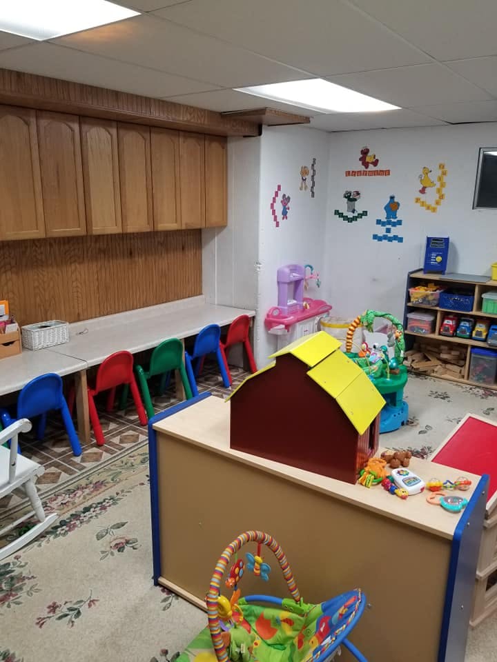 Playroom with small tables and chairs, toys, and wall decorations