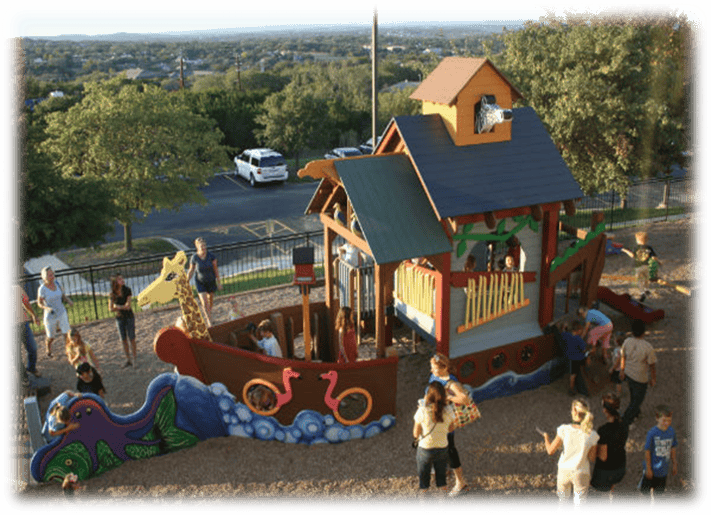 People and children playing on a large boat-shaped playground structure