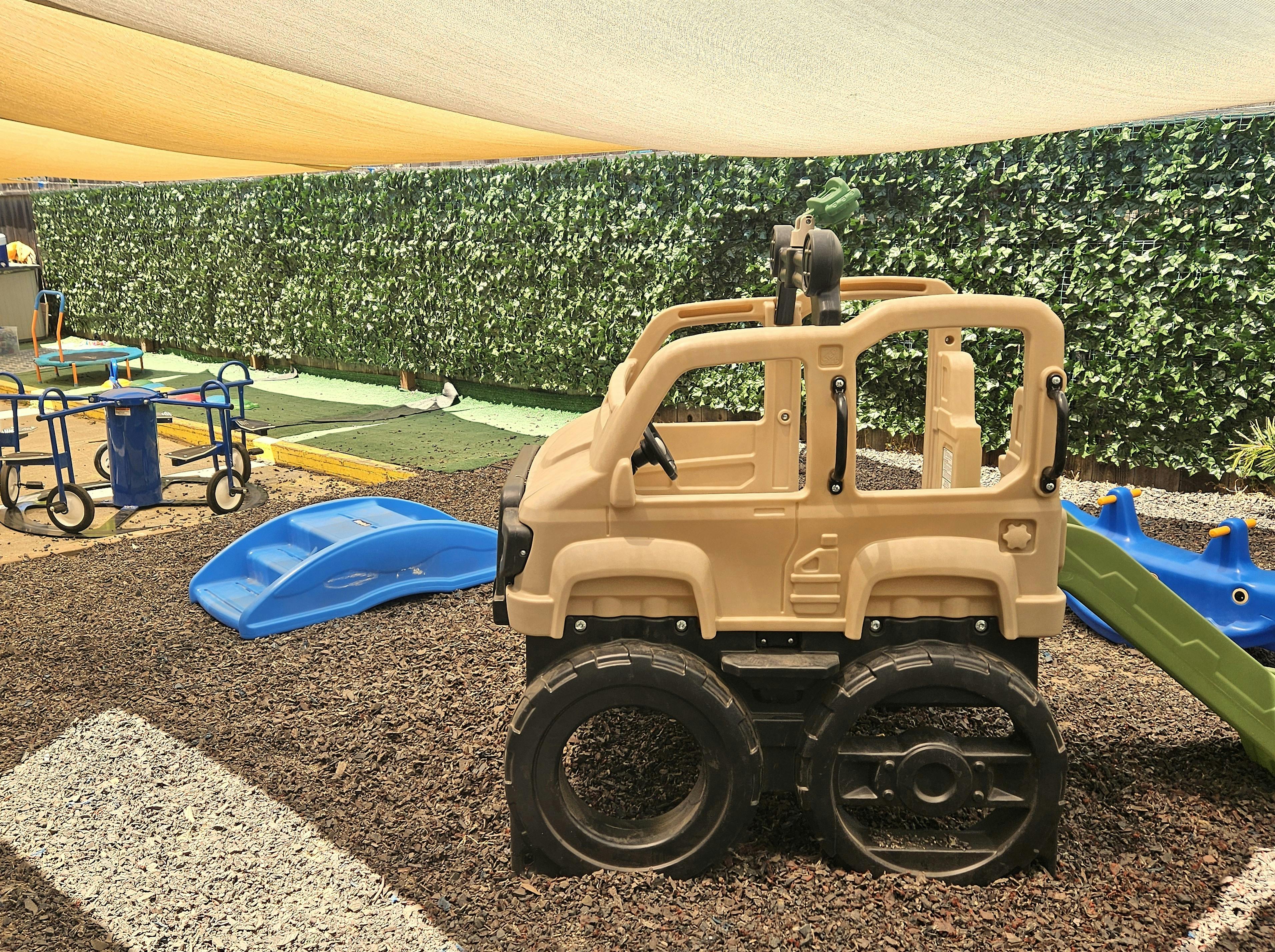 Toy jeep and blue slide on a playground