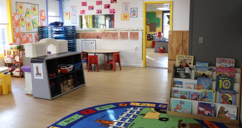 Empty classroom with small tables, chairs, and book displays