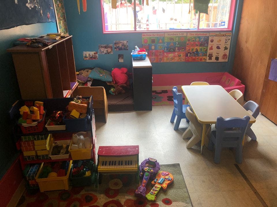Classroom with small table and chairs, toy storage, and window