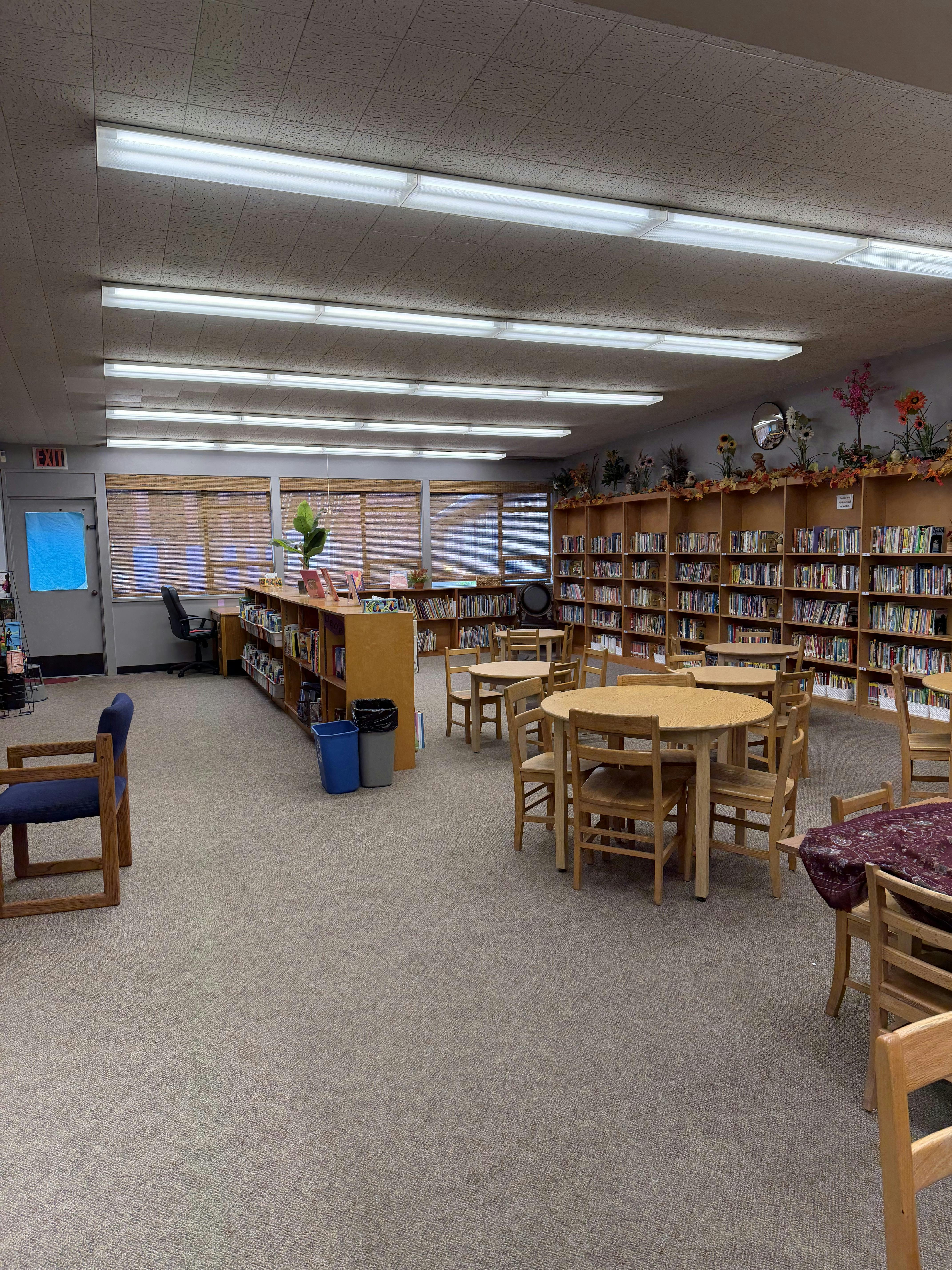 Library room with bookshelves, circular tables, and chairs