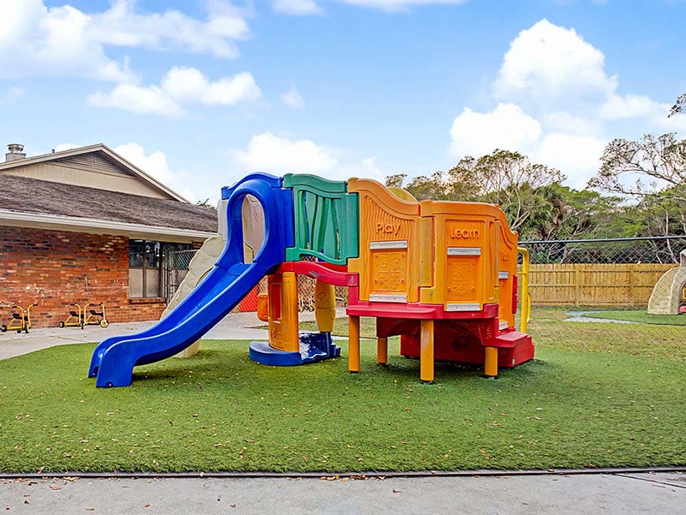 Colorful playground structure with slides on artificial turf