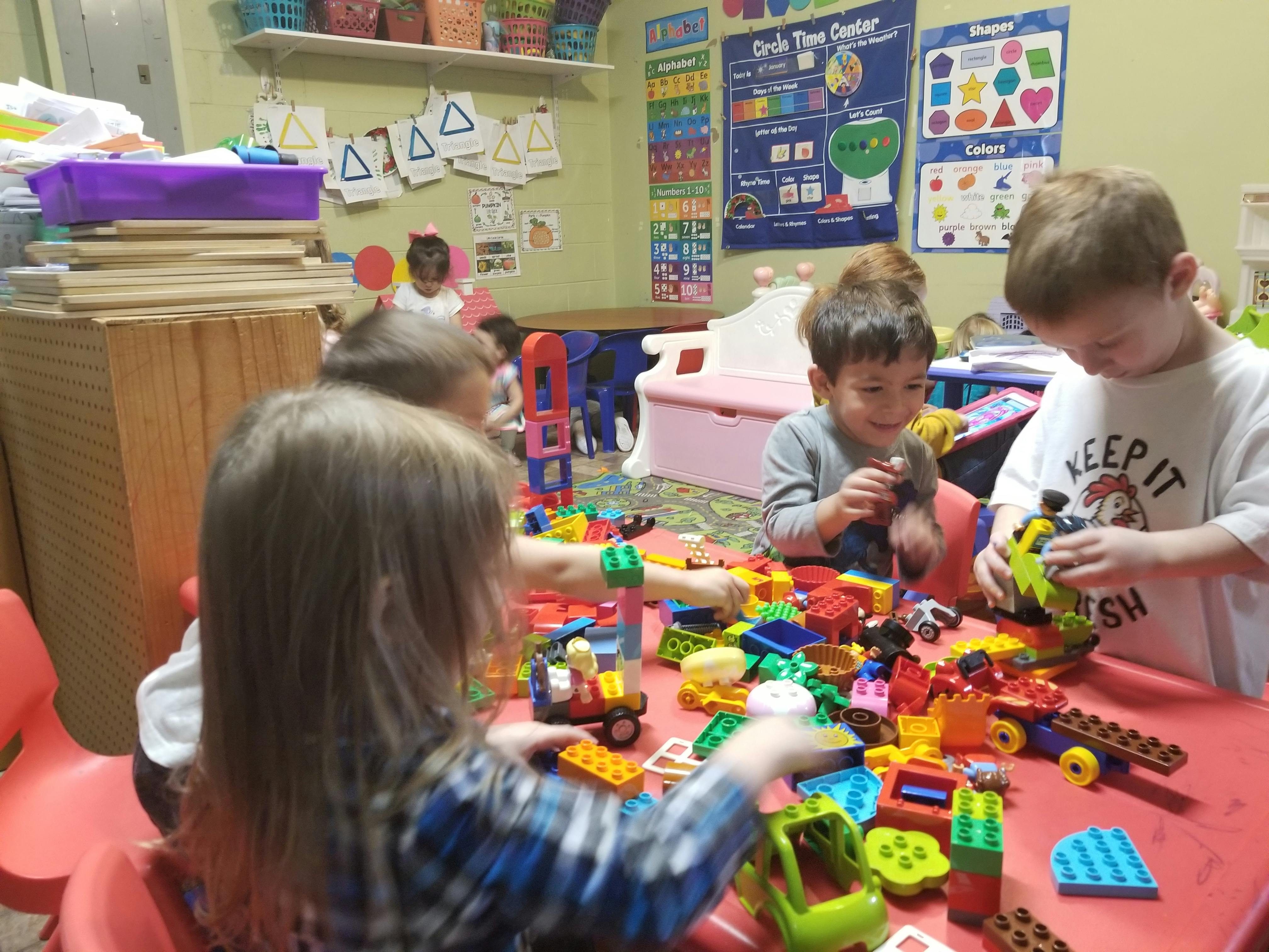 Children playing with colorful building blocks at a table
