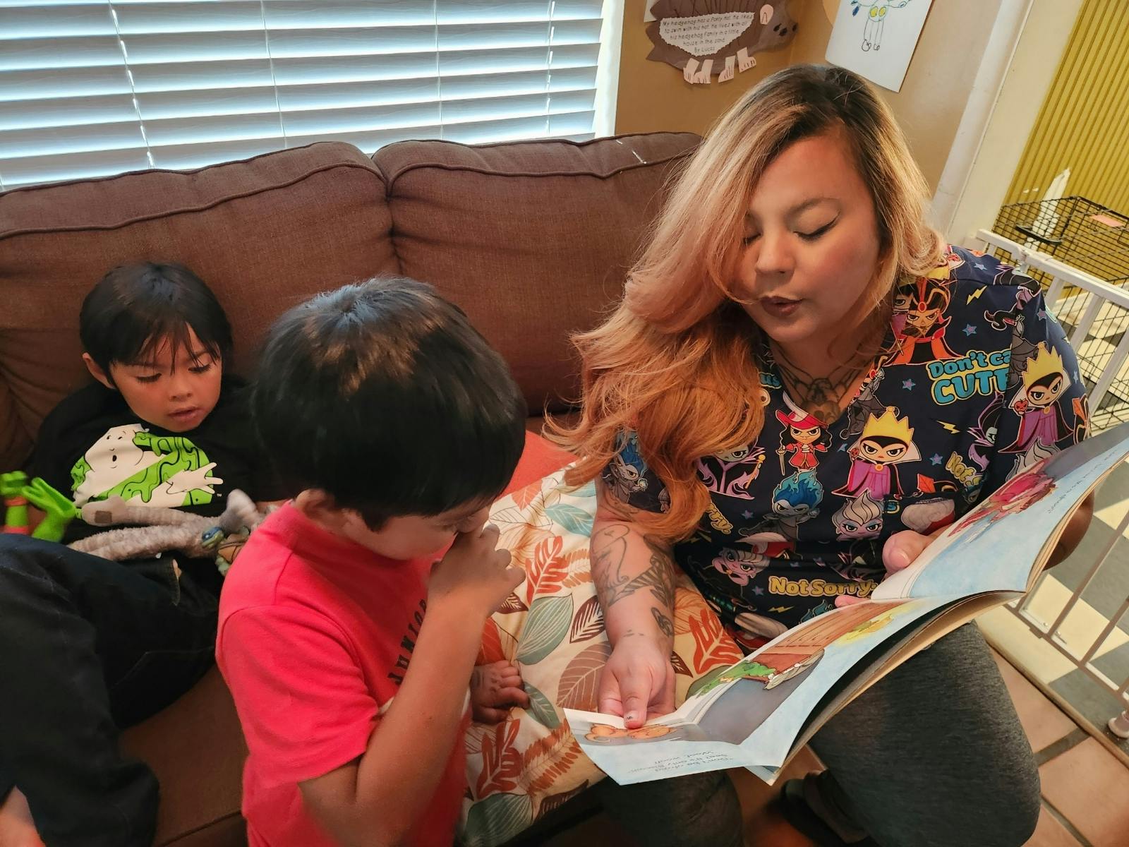 Person reading a book to two children