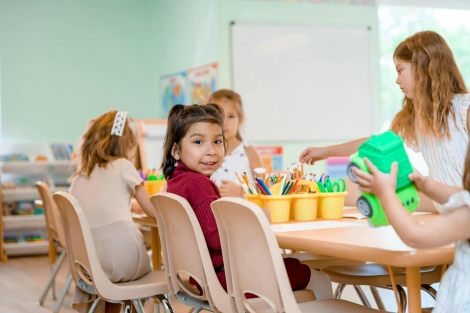 Children sitting at a table in a classroom