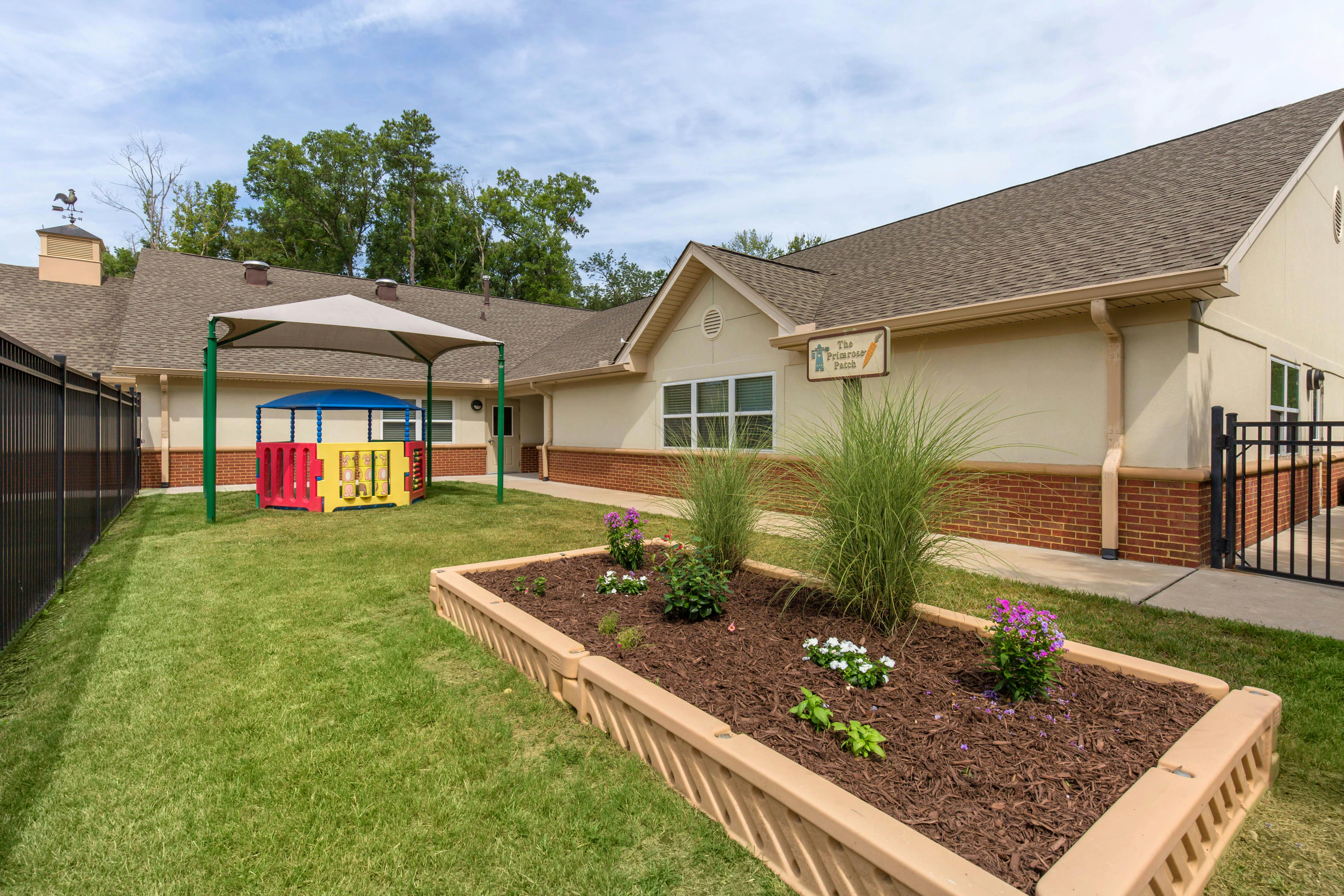 Childcare center building with a fenced play area and raised garden bed