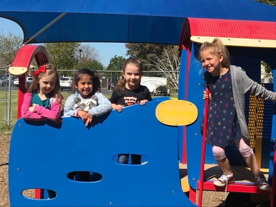 Four children on a playground structure
