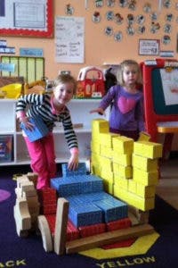 Two children playing with building blocks