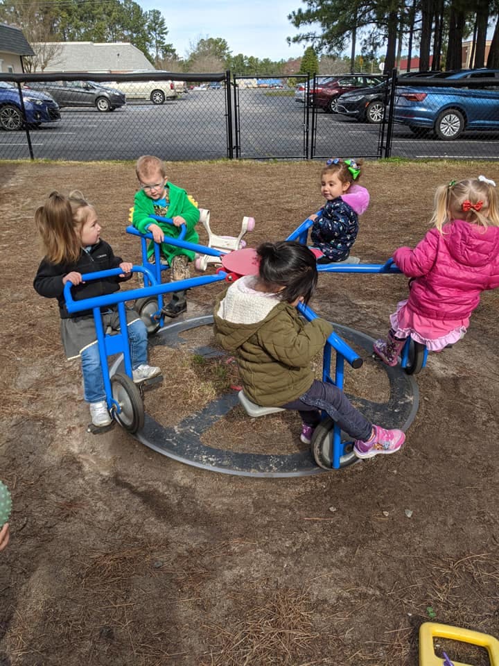 Children playing on a merry-go-round at a playground