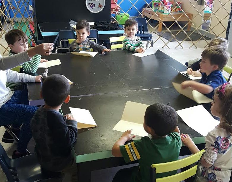 Adult and children sitting around a table with papers
