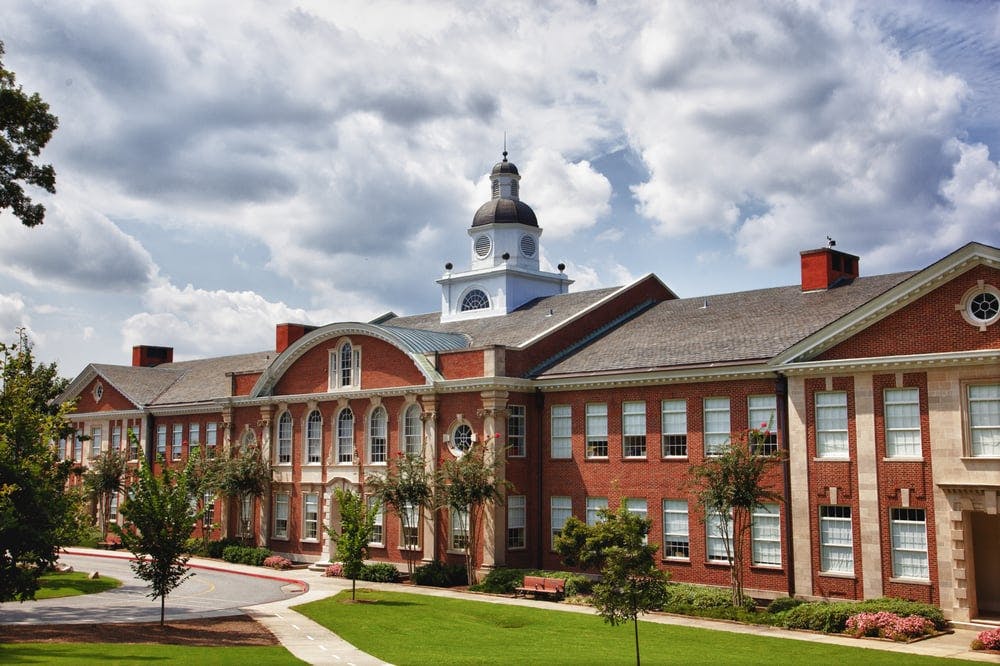 Large brick building with a white cupola on the roof