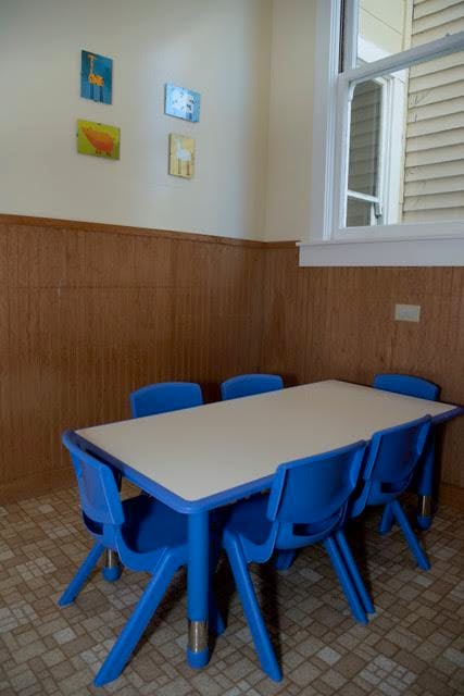 Small table with six blue chairs in a room