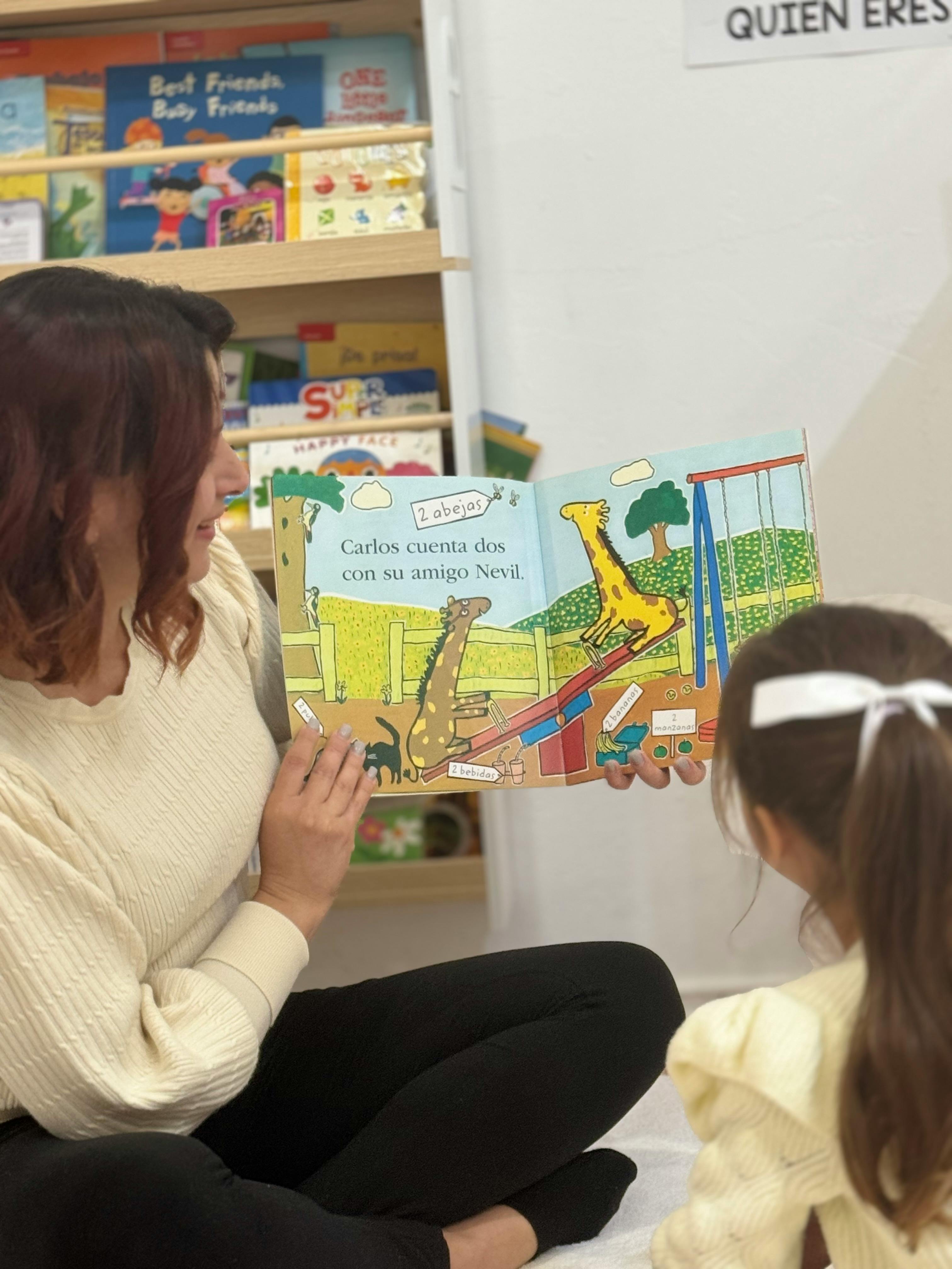 Person reading a book with giraffe illustrations to a child